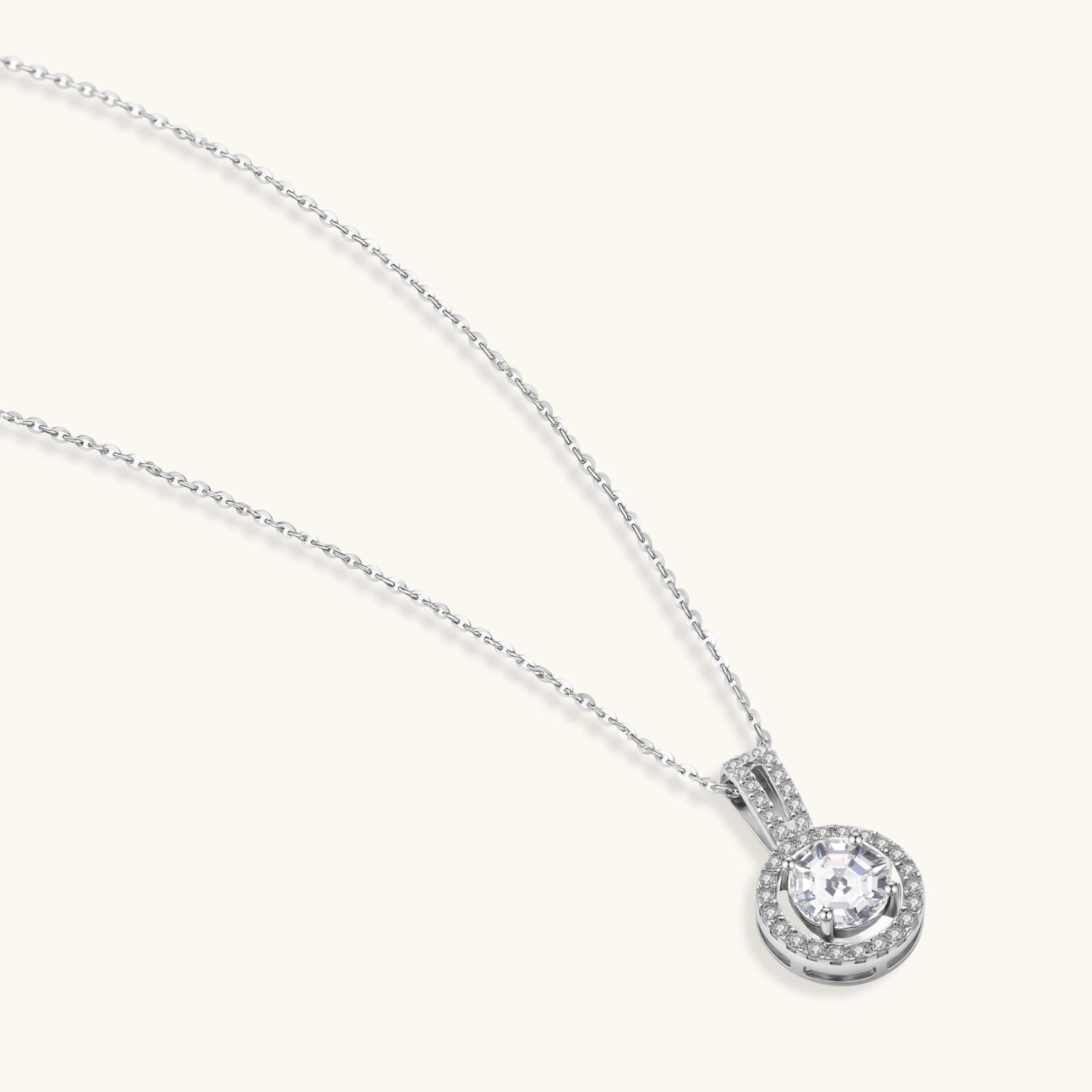 Platinum-plated sterling silver necklace with round halo pendant featuring central crystal surrounded by smaller stones